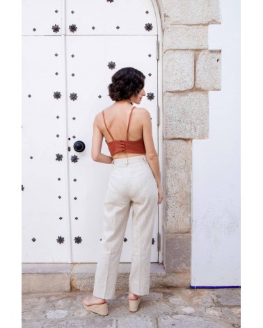Detalle de la cintura limpia y acabados del pantalón de lino beige claro.